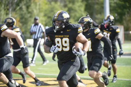 Huskies football needs overtime to defeat Peacocks for Homecoming